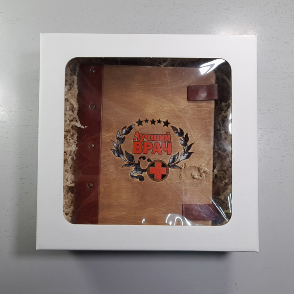 Подарочный набор для врача блокнот формата А5 в кожаном переплете с гравировкой «Лучший врач» в подарочной коробке из белого картона с прозрачным верхом и деревянной ручкой с рисунком-гравировкой Подарочный набор для врача блокнот формата А5 в кожаном переплете с гравировкой «Лучший врач» в подарочной коробке из белого картона с прозрачным верхом и деревянной ручкой с рисунком-гравировкой